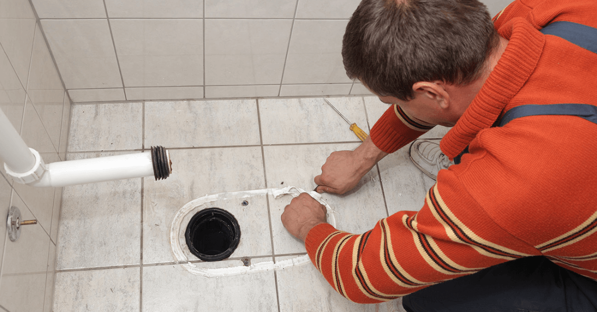 a plumber removing the toilet to access the clogged sewer drain